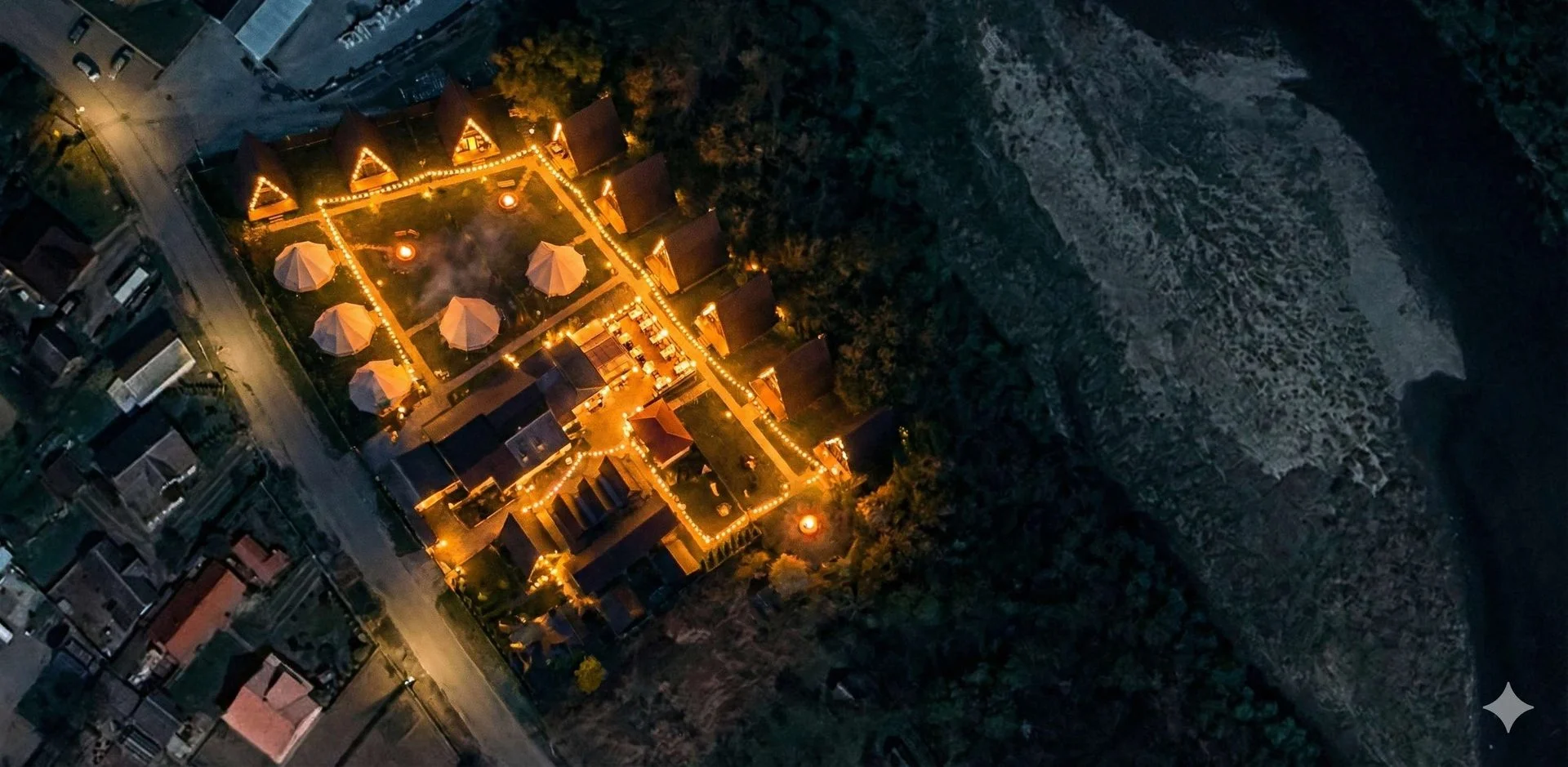 Нічний вигляд бази відпочинку з A-frame кабінами біля річки Прут